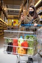 woman with phone checking shopping list app in grocery store Royalty Free Stock Photo