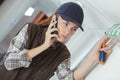 Woman on phone while fitting exit sign Royalty Free Stock Photo