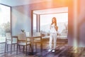 Woman with phone in gray dining room Royalty Free Stock Photo