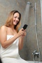Woman on the phone in the shower while is wasting water Royalty Free Stock Photo