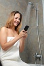 Woman on the phone in the shower while is wasting water