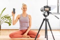 Woman with phone streaming for yoga blog at home Royalty Free Stock Photo