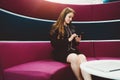 Woman phoning on purple curved sofa Royalty Free Stock Photo