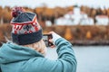 Woman photographer on a boat takes photos with her smart phone of a lighthouse, intentionally blurred in background Royalty Free Stock Photo