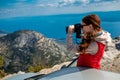 Woman photographer with car on the top of mountain Royalty Free Stock Photo