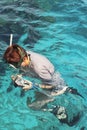 Woman photographer diving into water of Red sea