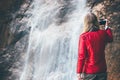 Woman photographer enjoying waterfall view