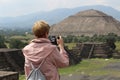 Woman photographer taking photo of Piramida de Sol Sun Piramide in Teotihuacan