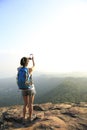 Woman photographer taking photos at mountain peak Royalty Free Stock Photo