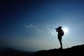 Woman photographer taking photos at mountain peak Royalty Free Stock Photo