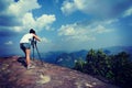 Woman photographer taking photos at mountain peak Royalty Free Stock Photo