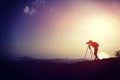 Woman photographer taking photos at mountain peak Royalty Free Stock Photo