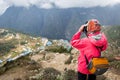 Woman photographer taking picture Namche Bazaar mountain village. Royalty Free Stock Photo