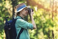 Woman photographer taking picture of nature with analog film camera in forest