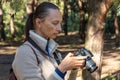 Woman photographer walking and taking picture photo of forest landscape. Royalty Free Stock Photo