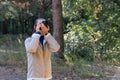 Woman photographer walking and taking picture photo of forest landscape. Royalty Free Stock Photo