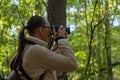 Woman photographer walking and taking picture photo of forest landscape. Royalty Free Stock Photo