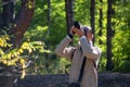 Woman photographer walking and taking picture photo of forest landscape. Royalty Free Stock Photo