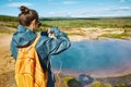 Woman photographing eruption of Strokkur Geyser in Iceland