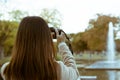 Woman photographing a fountain in Yoyogi park during autumn in Tokyo, Japan.