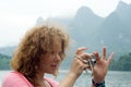 Woman photographing on a mountain river, Yangshuo, China