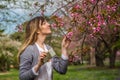 Woman smelling pink cherry blossom