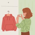 Woman Photographing Red Hoodie on Hanger.