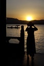 Woman photographing the sunset, West Lake, Hangzhou