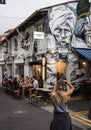 Woman Photographs Artwork in Haji Lane, Singapore Royalty Free Stock Photo