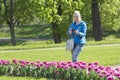 Woman photographs a flower bed with spring blooming tulips