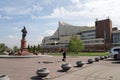 Woman photographs a monument to statesman N.P. Rezanov on the square in front of the Great Concert Hall in the city of Krasnoyarsk