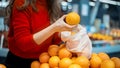 Woman picking oranges in a reusable bag. Ecology, Earth Day thematics