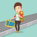 Woman picking up suitcase on luggage conveyor belt