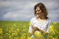 Woman picking yellow flowers in field. Royalty Free Stock Photo