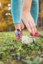 A woman picks up a badminton shuttlecock from the grass. Close-up of the hand. Active lifestyle