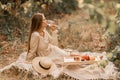 Woman picnic vineyard. Romantic dinner, fruit and wine. Happy woman with a glass of wine at a picnic in the vineyard on