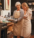 Woman, pie and cooking with grandmother in kitchen for bonding, instruction and baking tips. Dinner, house and chef with Royalty Free Stock Photo