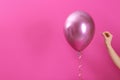 Woman piercing balloon with needle on color background, closeup.