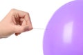 Woman piercing purple balloon on white background