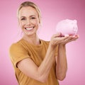 Woman, piggy bank and portrait for savings on pink background, studio and backdrop. Happy female holding financial tin