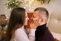 A woman pinches her husband`s cheeks making a funny face.