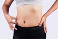 Woman pinching belly fat after weight loss