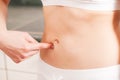 Woman pinching her flat belly