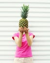 Woman and pineapple on her head standing over white