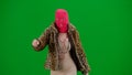 Woman in pink balaclava, tiger fur coat and evening dress walking and dancing merrily with her hands up. Woman freak on Royalty Free Stock Photo