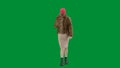 Woman in pink balaclava, tiger fur coat and evening dress walking. Woman freak on green background in studio. Fashion Royalty Free Stock Photo