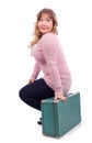 Woman in pink blouse sits on suitcase Royalty Free Stock Photo