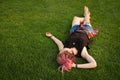 Woman with pink dreadlocks resting on the grass Royalty Free Stock Photo