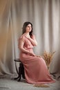 Woman in a pink dress on a background of linen fabric. Copy, empty space for text Royalty Free Stock Photo