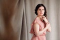 Woman in a pink dress on a background of linen fabric. Copy, empty space for text Royalty Free Stock Photo